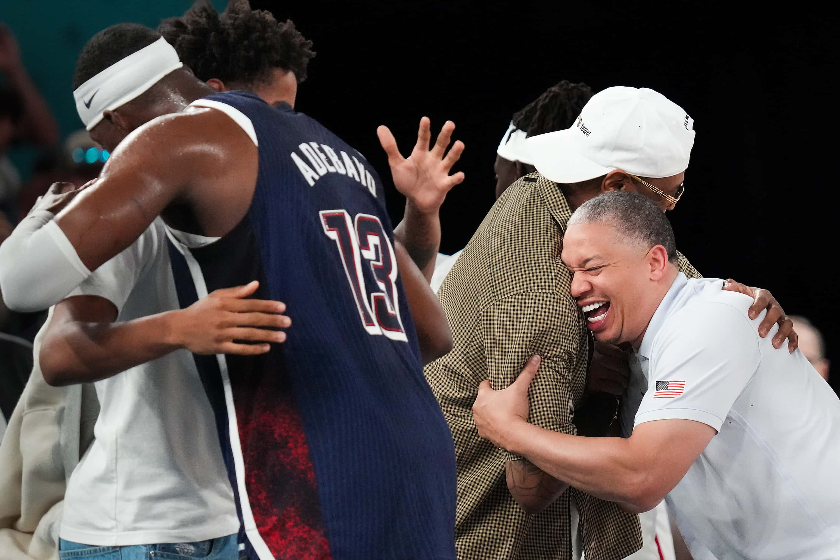 Team USA assistant coach Tyronn Lue hugs former NBA player Carmelo Anthony after a victory...