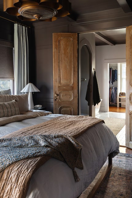 Bedroom with antique doors, an overhead light and a cozy bed