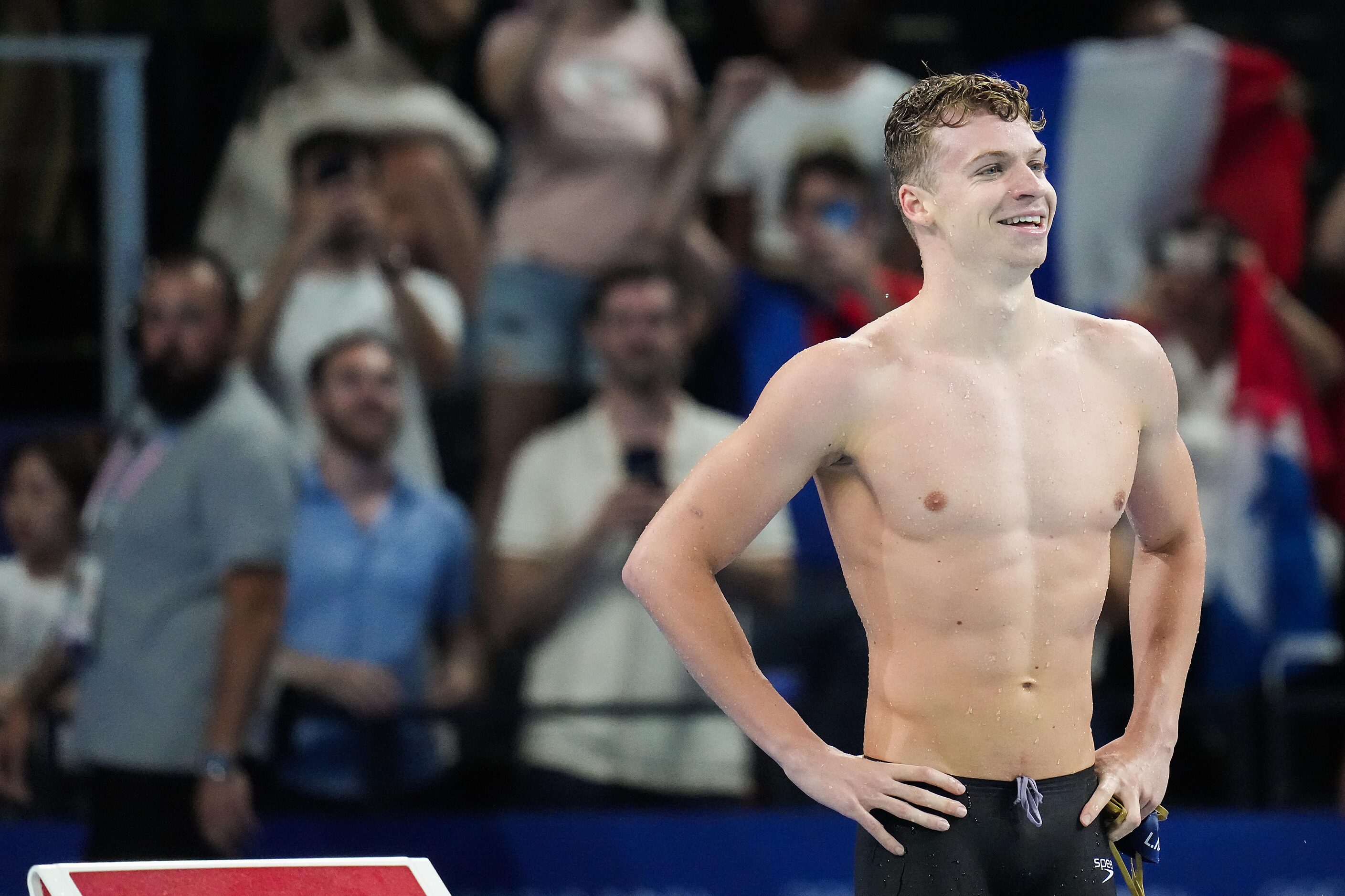 Fans cheer Leon Marchand of France celebrates after winning the men’s 200-meter breaststroke...