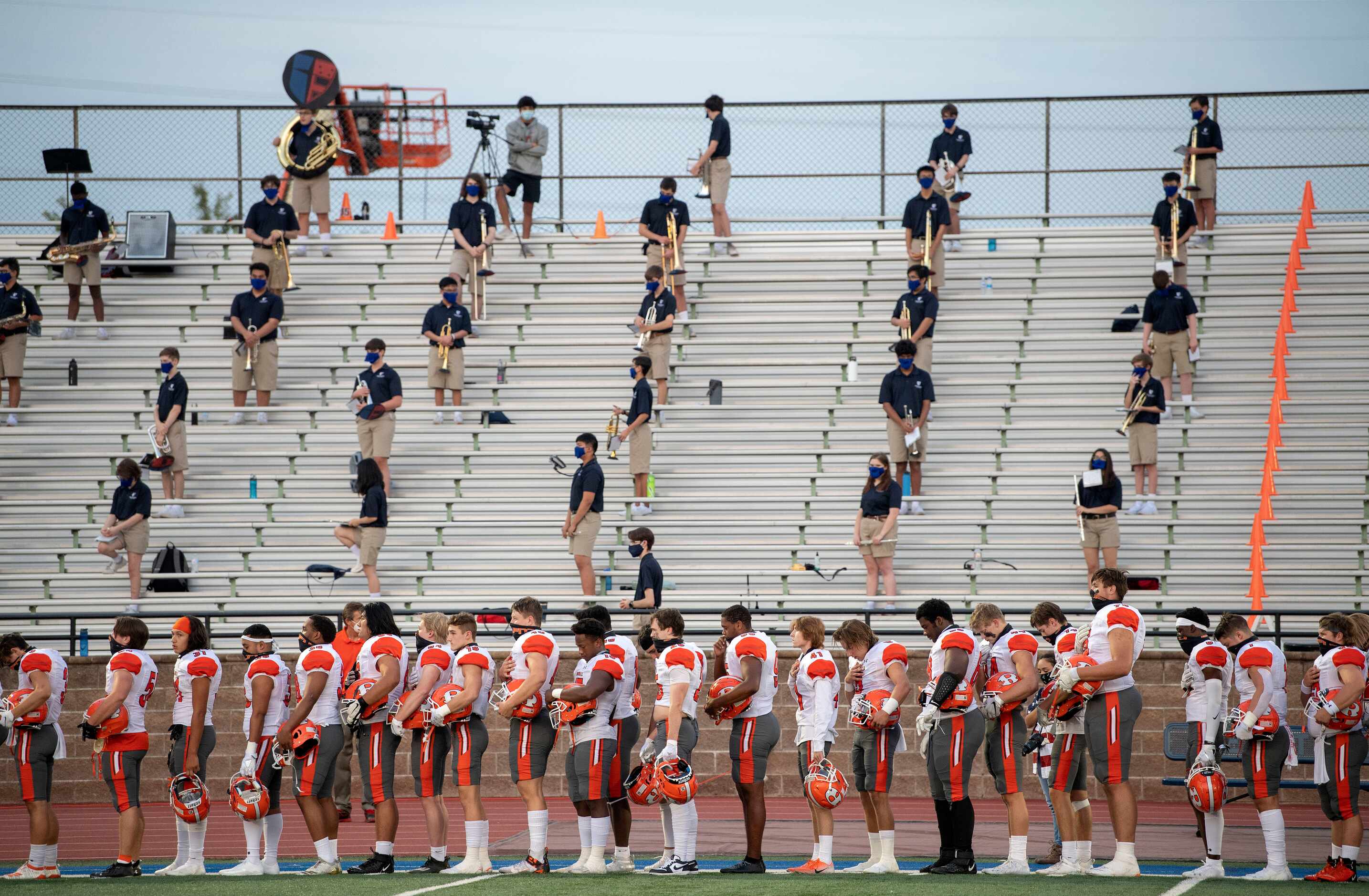 The Jesuit band practices social distancing and the Rockwall football team stands at...