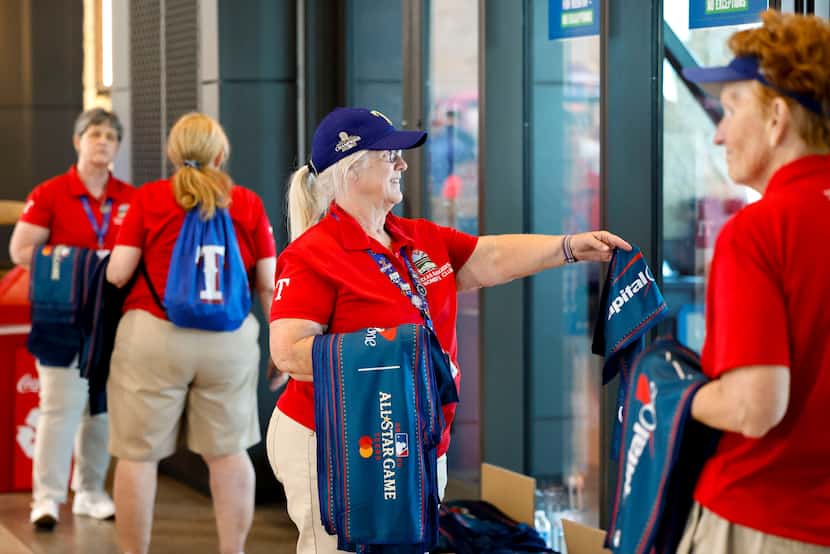 Texas Rangers Women’s Club members hand out towels ahead of MLB All-Star baseball game, on...
