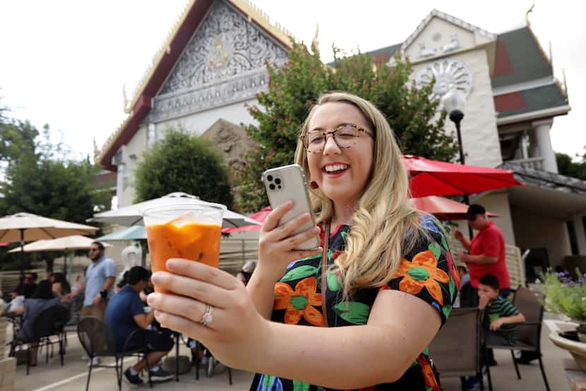 Julie Wells takes a photo of her Thai tea during the Sunday Thai Food Market.