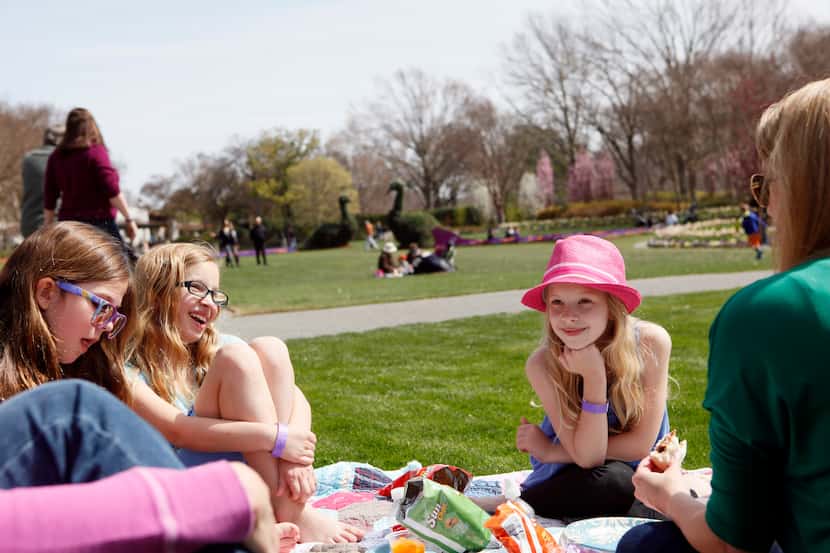 Alexis Dwyer, Isabella Kelley and Lilly Kelley sit with their mothers during a picnic in the...