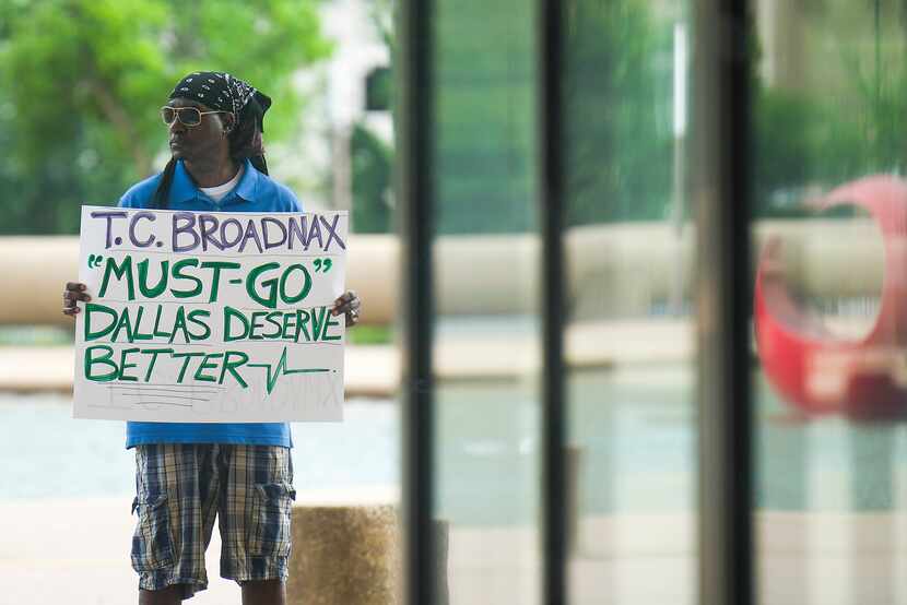 A man holding a sign calling for the ouster of Dallas City Manager T.C. Broadnax stood...