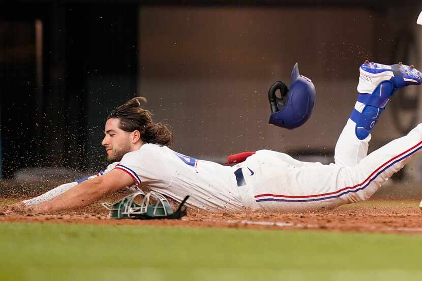 Texas Rangers Josh Smith slides safely into home plate for an inside-the-park home run...