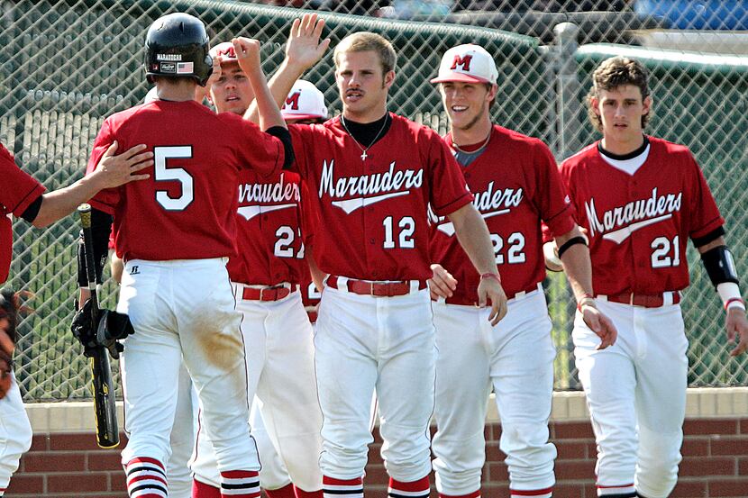 Flower Mound Marcus High School's Nick Lewis (5) is congratulated by Trey Mound (12) and...