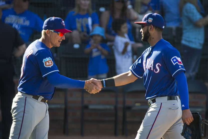 Texas Rangers outfielder Nomar Mazara gets a hand from manager Jeff Banister after a spring...