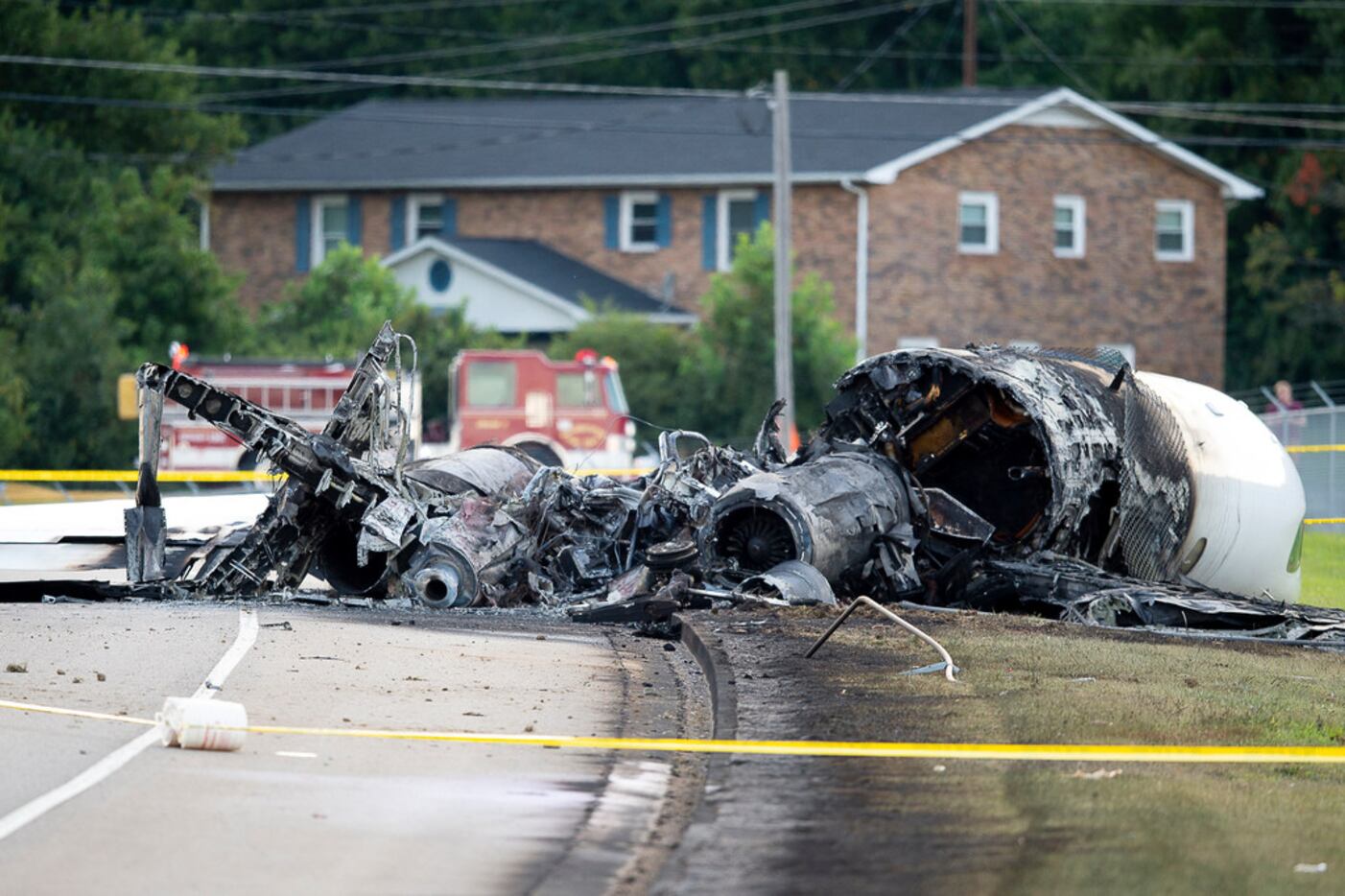 The charred remains of a plane lie along Highway 91 near Elizabethton Municipal Airport in...