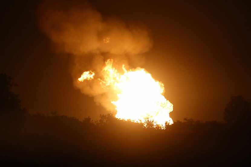 A massive fire illuminates the horizon Sunday night after a natural gas pipeline explosion...