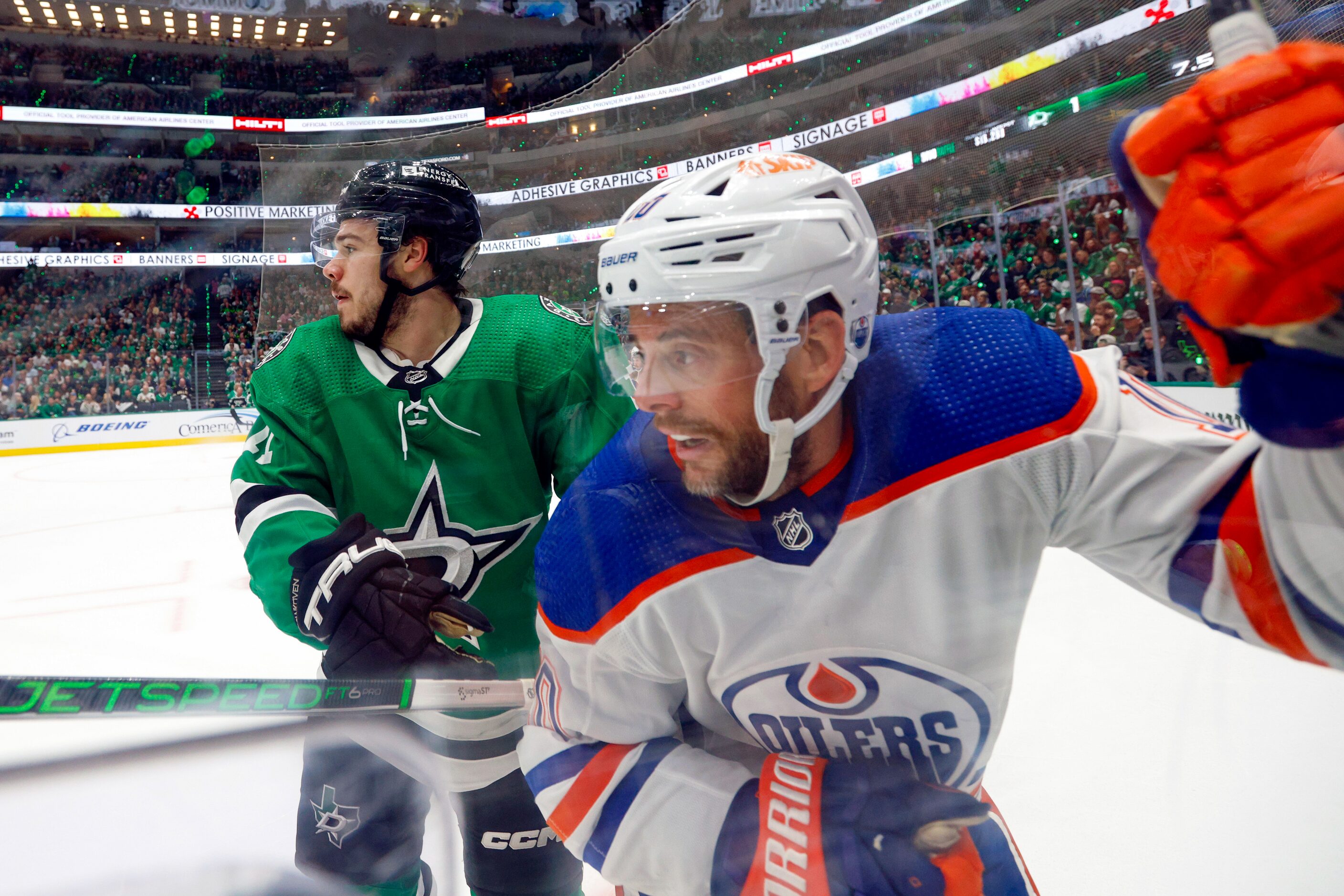 Dallas Stars center Logan Stankoven (11) checks Edmonton Oilers center Derek Ryan (10) into...