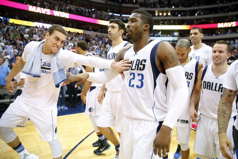 Dallas Mavericks guard Wesley Matthews (23) is congratulated by teammates after swatting...