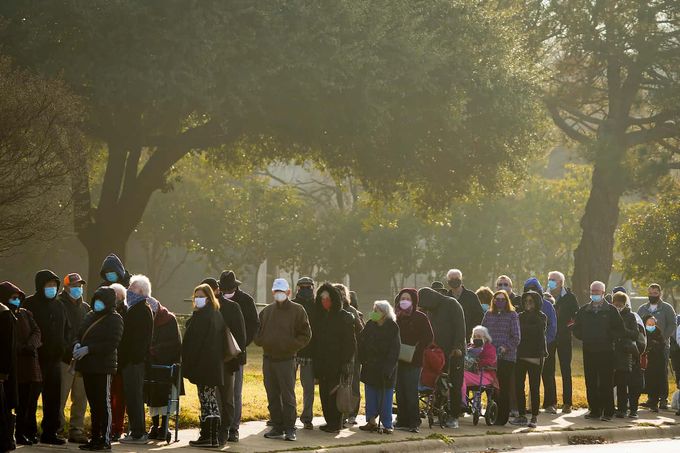 People wait in a long line to receive the COVID-19 vaccine at Fair Park on Monday, Jan. 11,...
