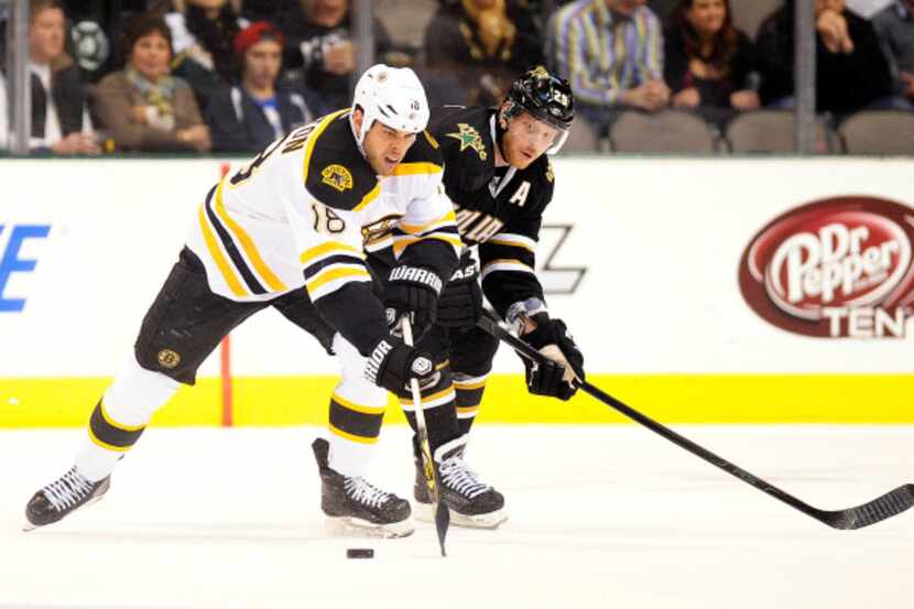Boston right wing Nathan Horton (18) and Dallas center Steve Ott (29) go after the puck in...