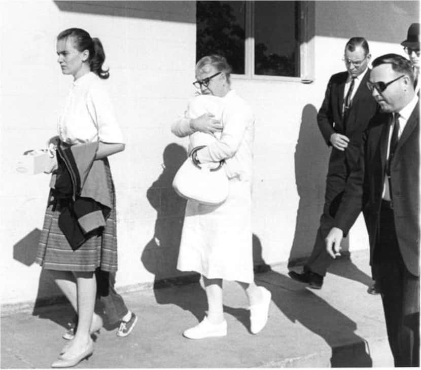 
Secret Service agents, including Howard, follow Marina Oswald (left), holding June’s hand,...