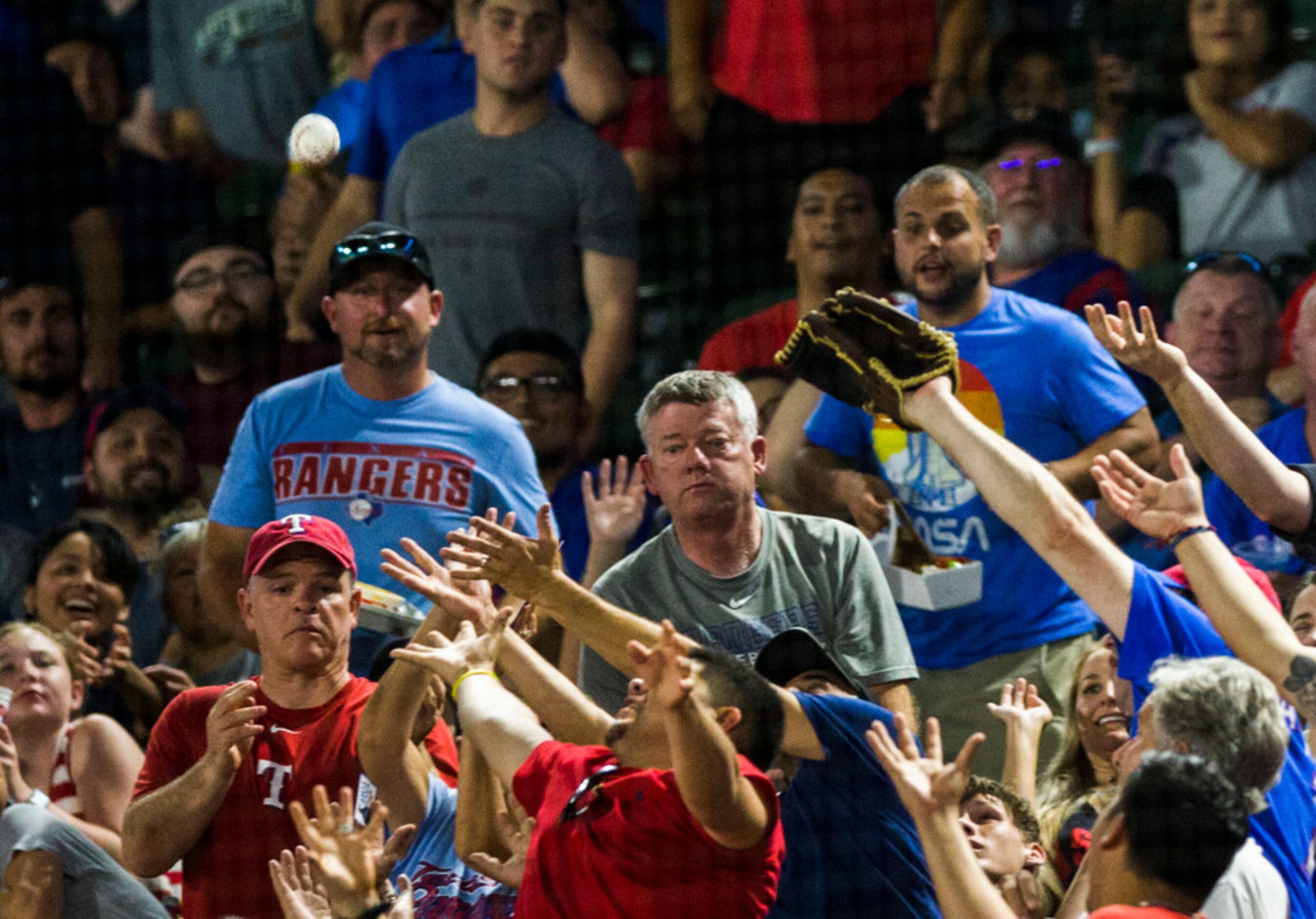 Fans reach for a foul ball during the fourth inning of an MLB game between the Boston Red...