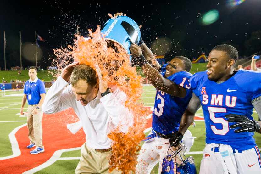 SMU wide receiver Ryheem Malone (13) dunks head coach Chad Morris with Powerade after the...