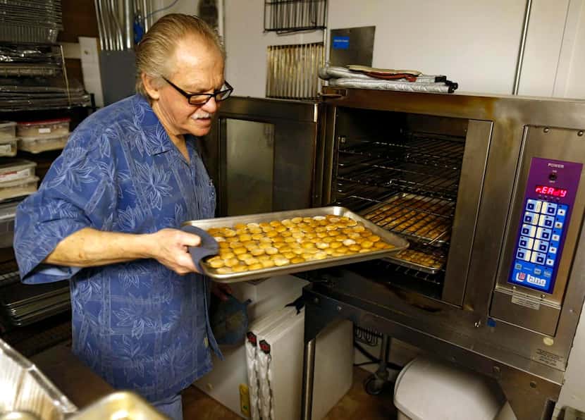 
Craig Farrar removes finished dog treats from the oven at The Canine Cookie Company in...