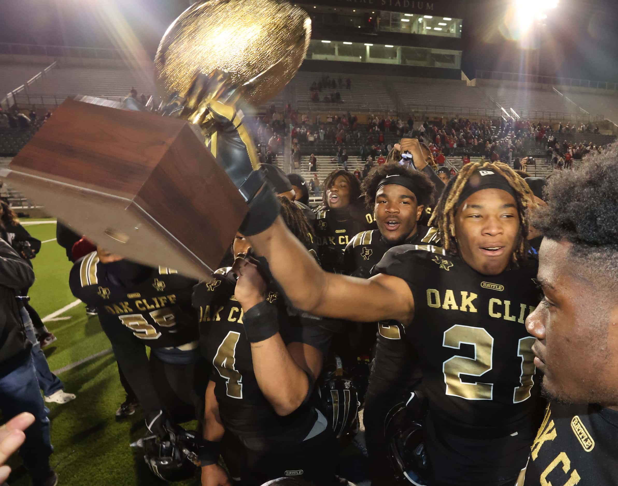 South Oak Cliff high Rb Danny Green (21) holds the Regional Semi-Finals trophy high after...