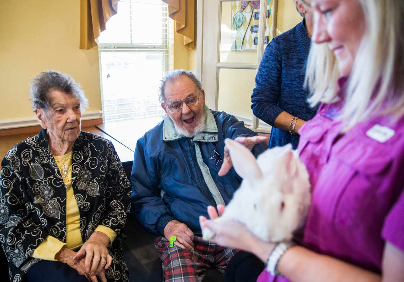 Jerry Holdridge, center, reacts to touching Snow the rabbit as Stacy Danby, right, of ARoo4U...