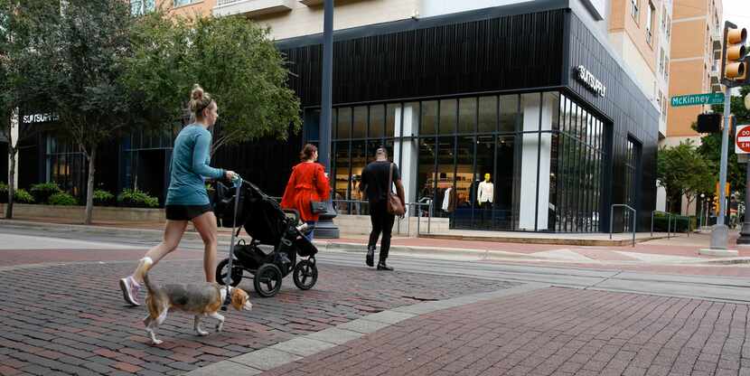 Pedestrians walk across McKinney Ave near Suit Supply in the West Village in Dallas. (Brian...