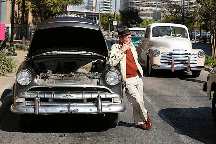  Clay Dove, a movie extra actor, waits for filming to begin next to classic cars in Dealey...