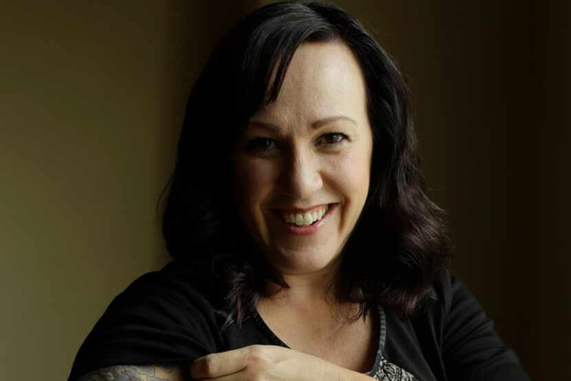 MJ Hegar pulls up her sleeve to reveal part of a tattoo that winds around her arm and back,...