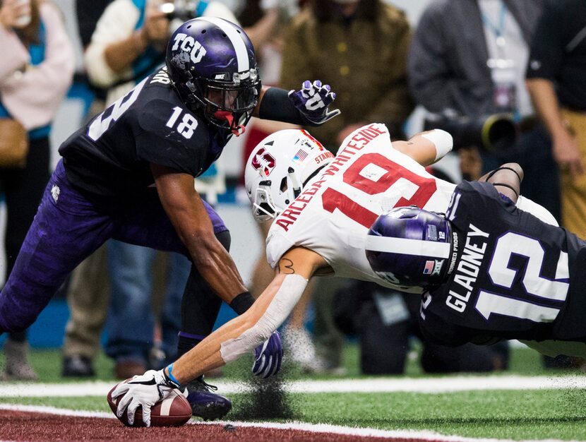 TCU Horned Frogs safety Nick Orr (18) and cornerback Jeff Gladney (12) tackle Stanford...