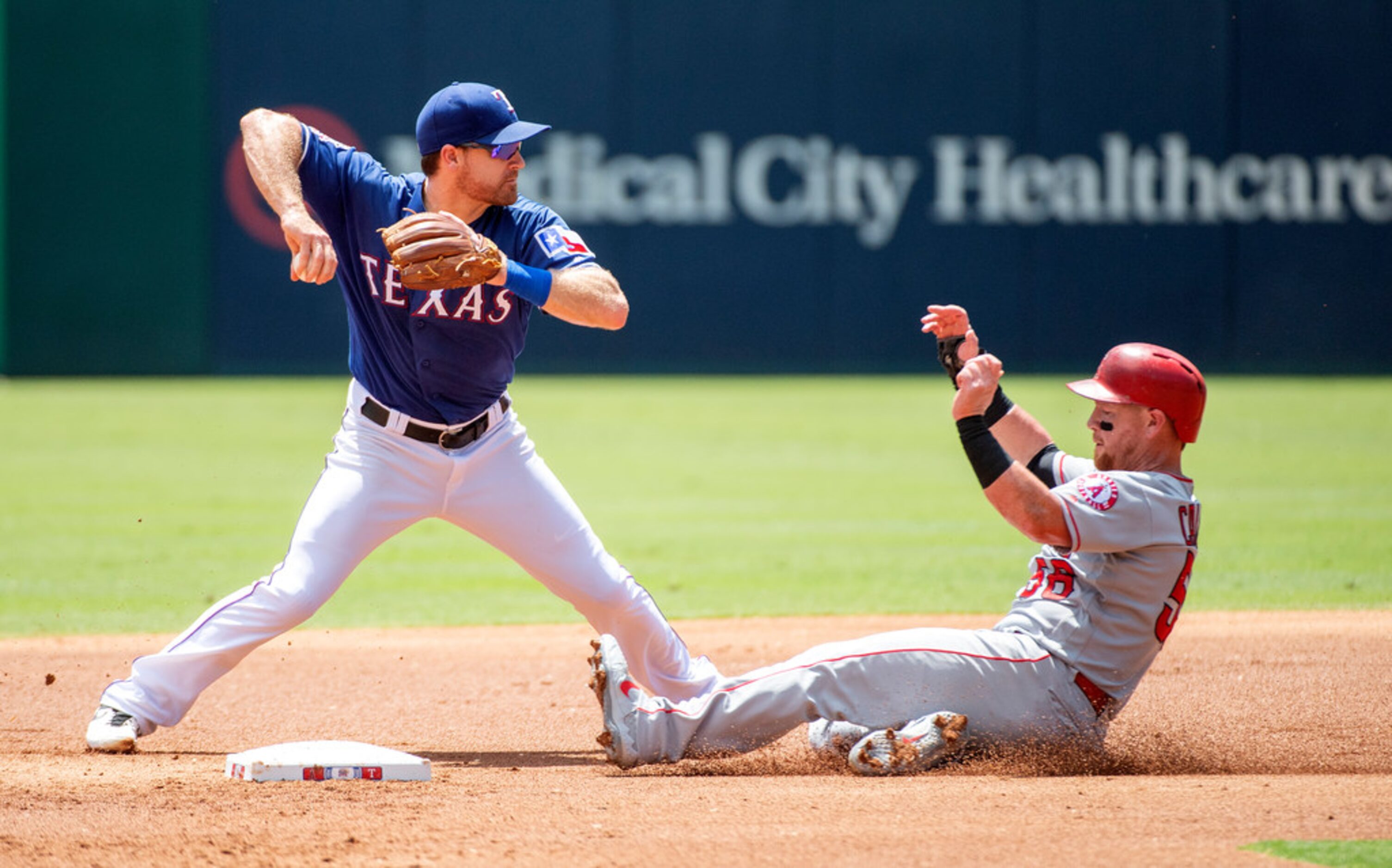 Texas Rangers shortstop Logan Forsythe, left, puts out Los Angeles Angels' Kole Calhoun on a...