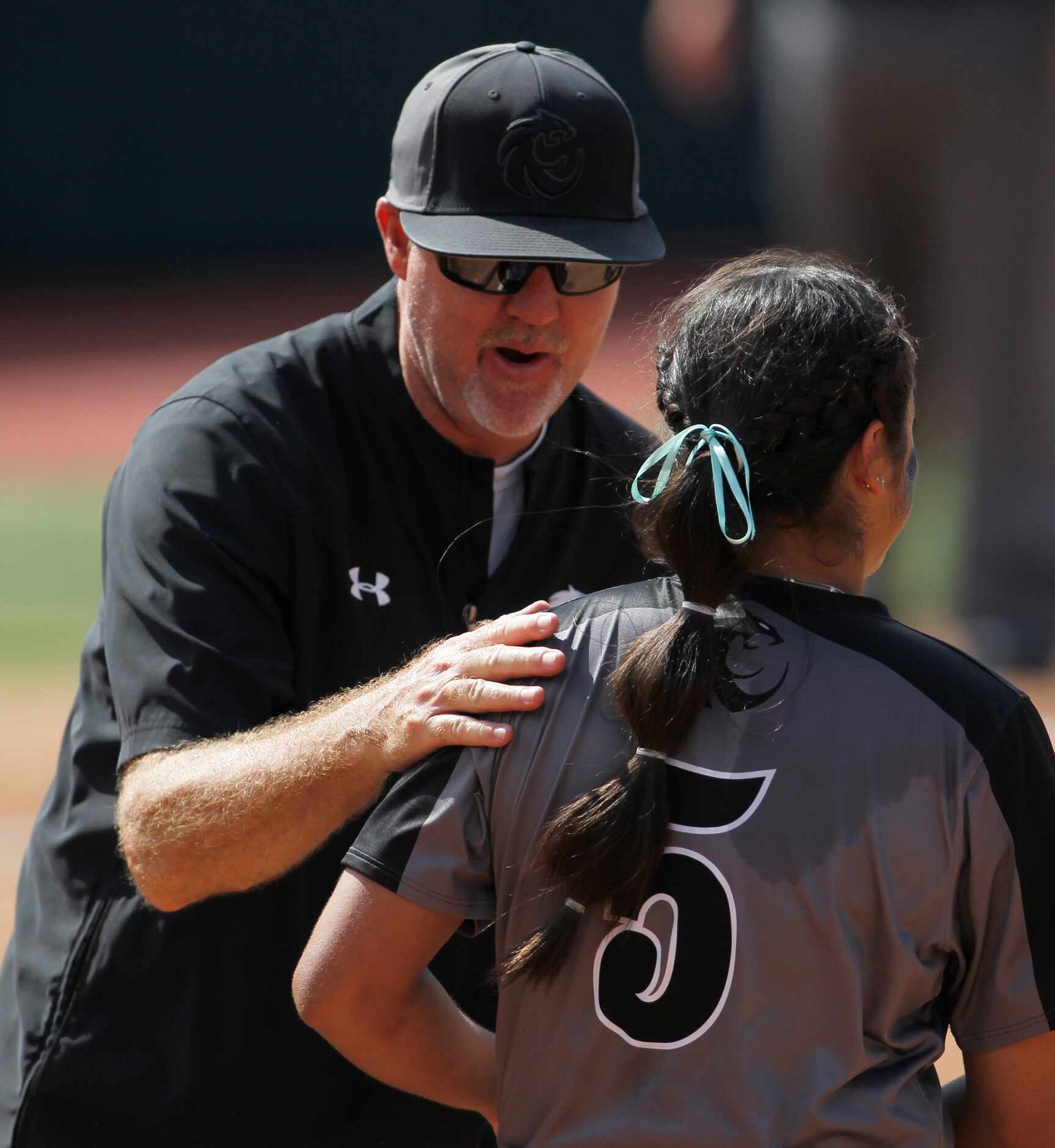 Denton Guyer head coach Keith Medford shares a word of encouragement with pitcher Jenny...
