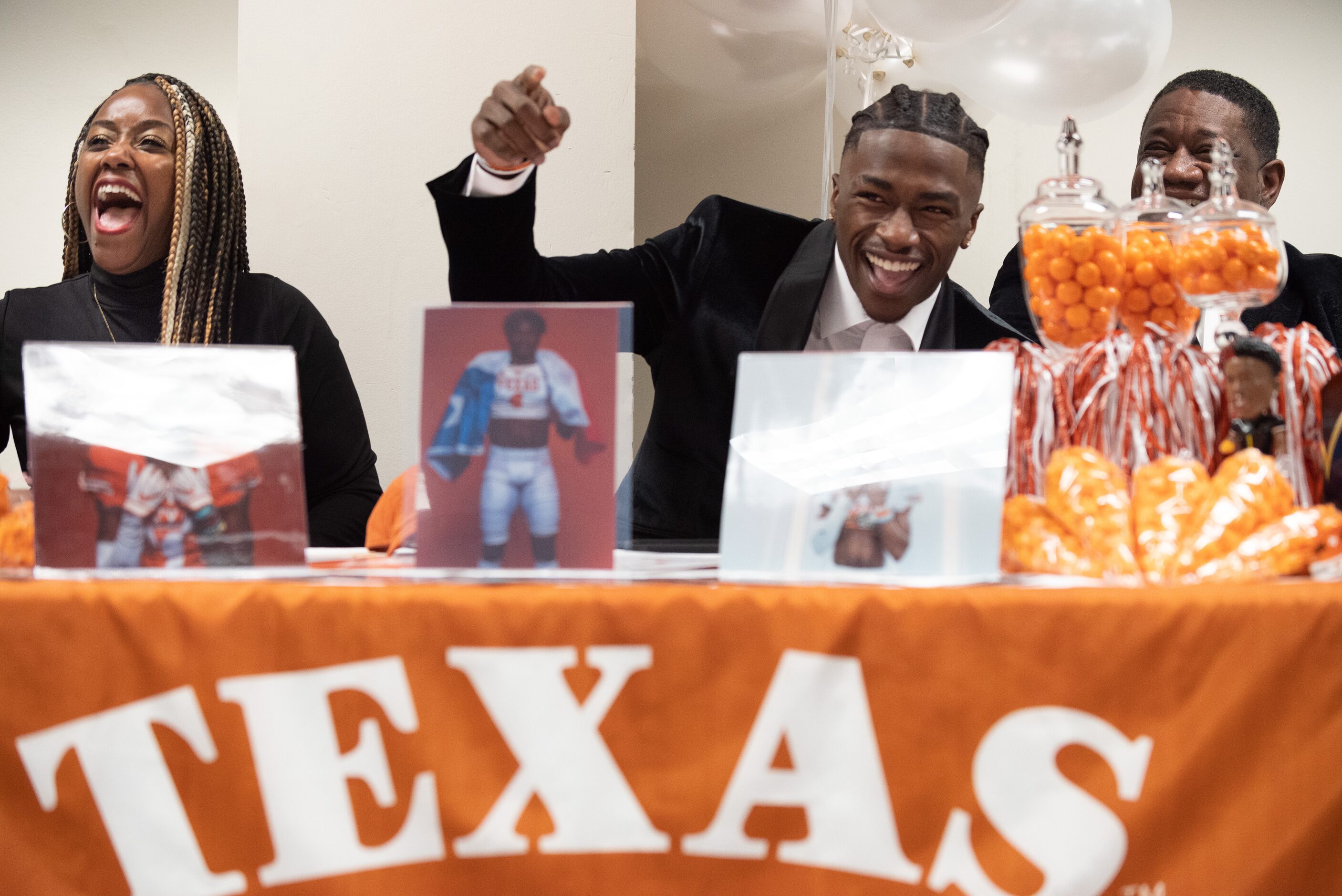 DeSoto high school football player Johntay Cook II, center, reacts with laughter as he sits...