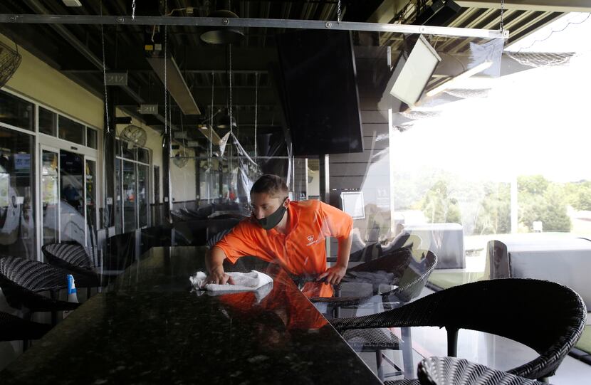 On the other side of a recently installed plastic liner, Kyle Harris cleans tables and seats...