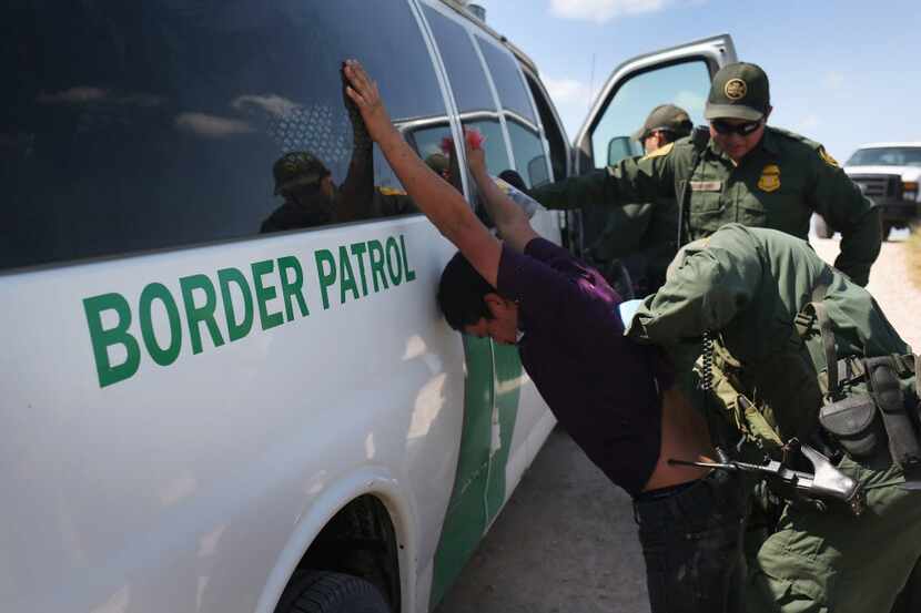U.S. Border Patrol agents detain undocumented immigrants after they crossed the border from...