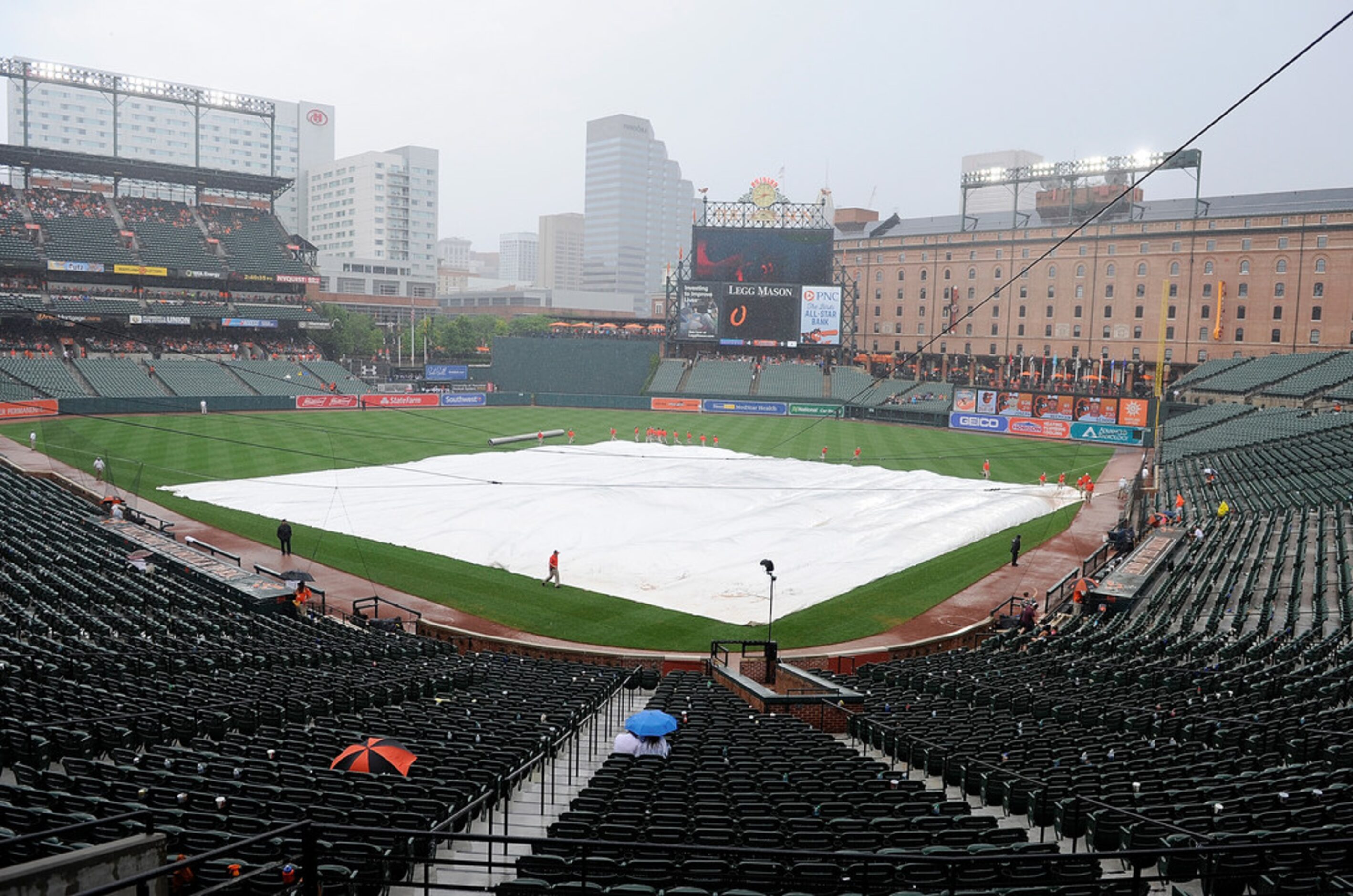 BALTIMORE, MD - JULY 15: The grounds crew puts the tarp on the field for a rain delay in the...