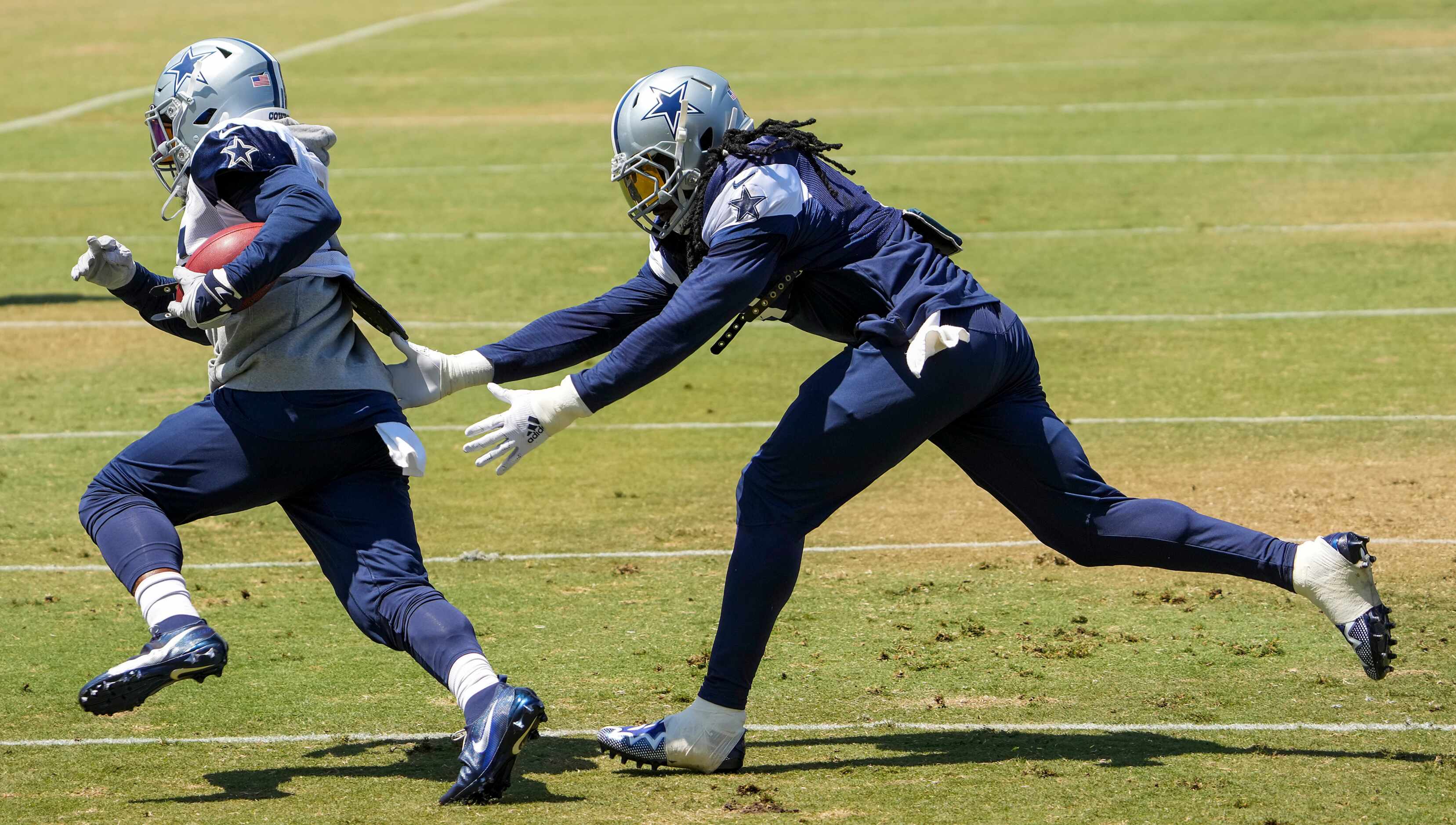 Dallas Cowboys running back Ezekiel Elliott (21) tries to get past linebacker Jaylon Smith...