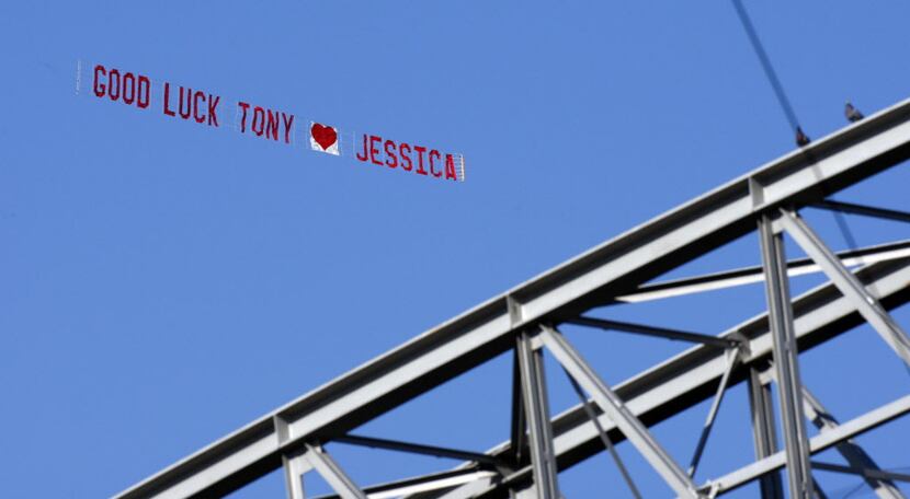 An advertising plane drags a banner reading " Good Luck Tony - Jessica" is flown around...