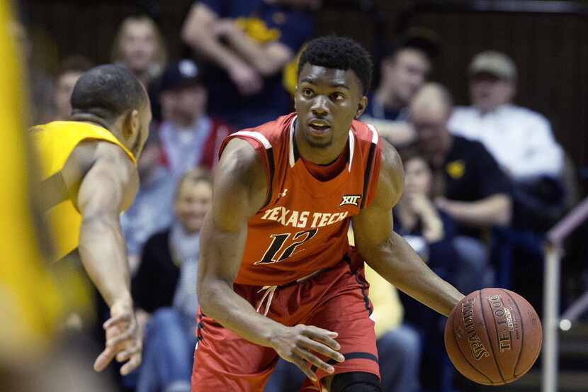 Texas Tech guard Keenan Evans (12) brings the ball up court as West Virginia guard Jevon...