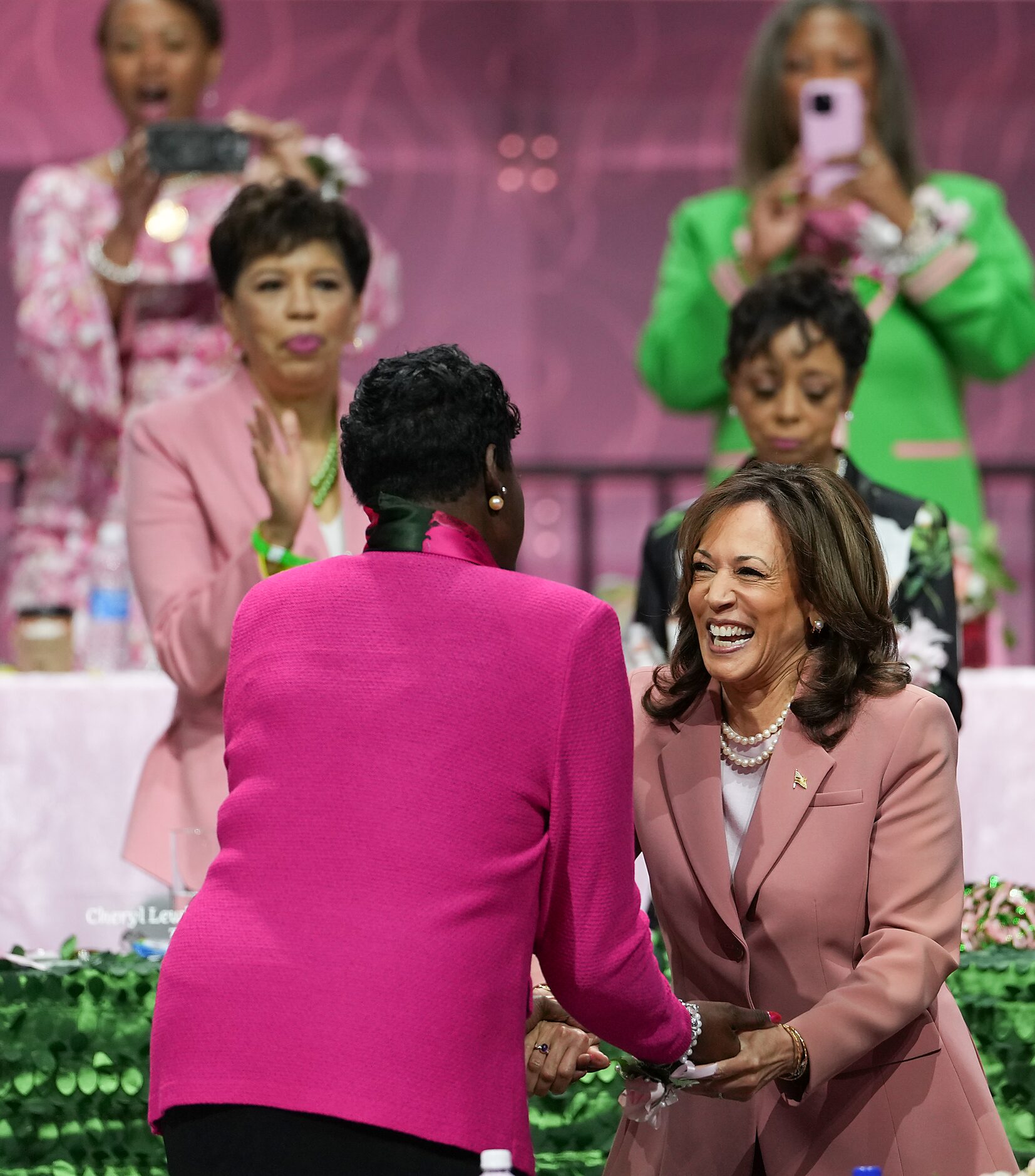 Vice President Kamala Harris (facing) shakes hands with Dorothy Buckhanan Wilson as she...