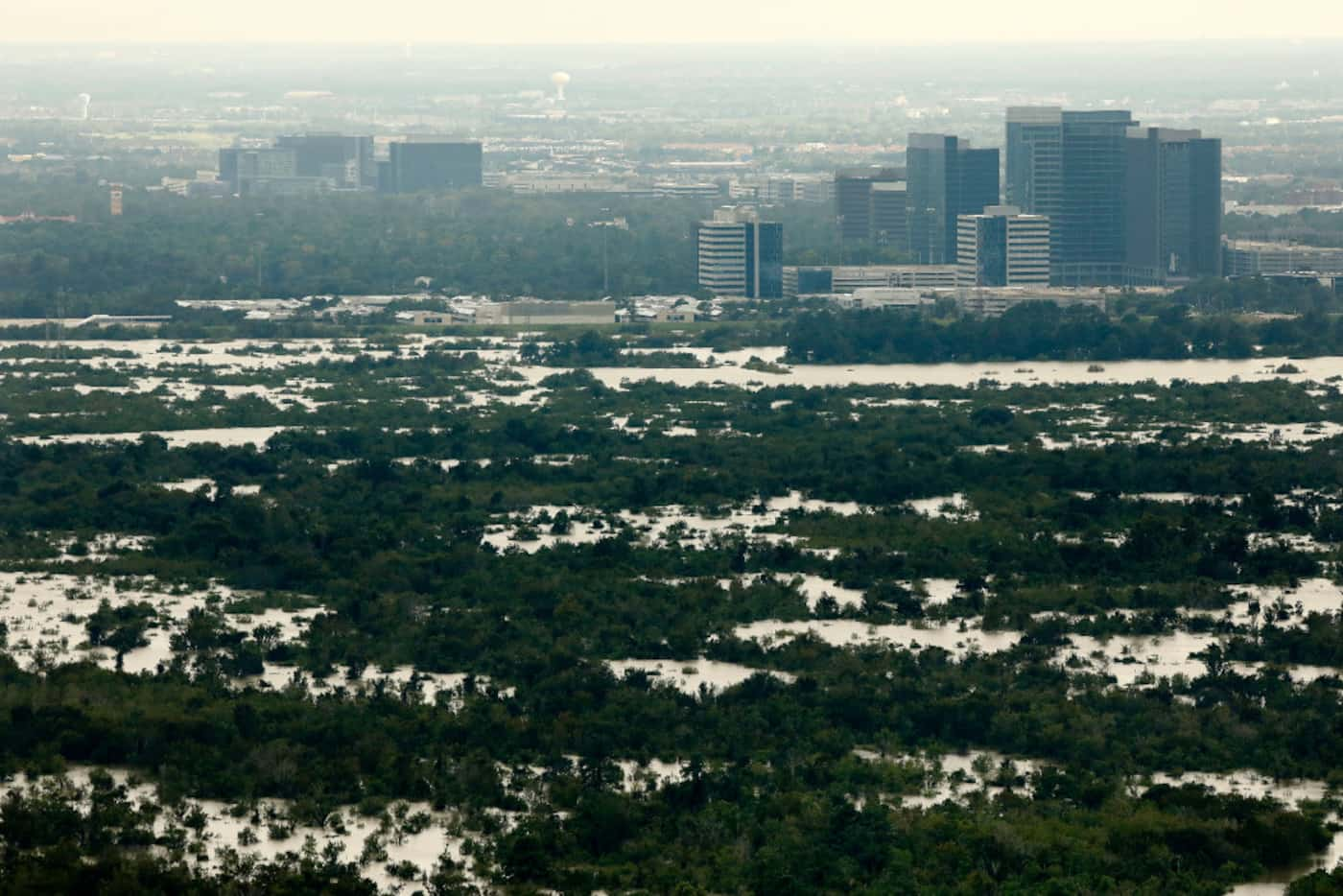 The Addicks Reservoir floods before buildings lining the Energy Corridor near Katy, Texas,...