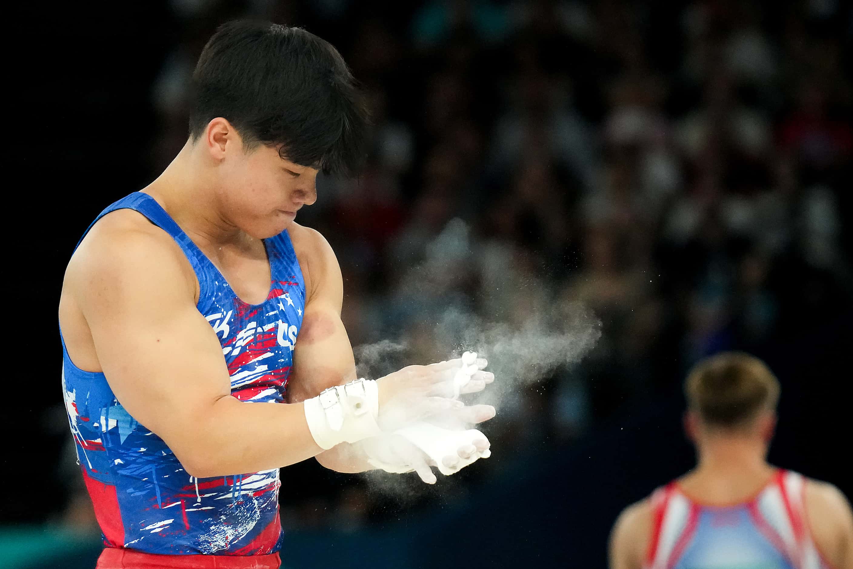 Asher Hong of the United States reacts after competing on the high bar during men’s...