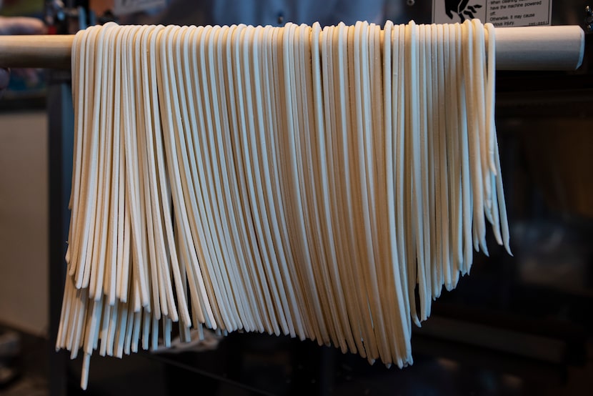 Aki Matsuo holds freshly cut noodle dough at Marugame in Carrollton.