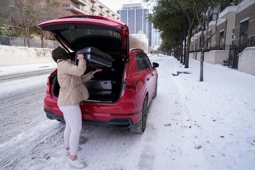 Abby Belton loads bags into her car as she prepares to depart her apartment in Victory Park...