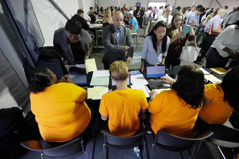  In this Wednesday, Aug. 2, 2017, file photo, job candidates are processed during a job fair...