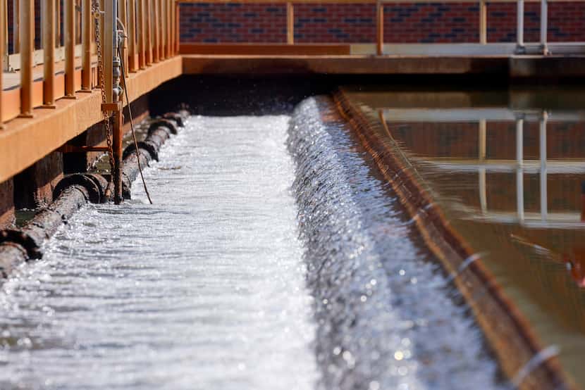 Water flows over the edge of a sedimentation basin at the Bachman Water Treatment Plant,...