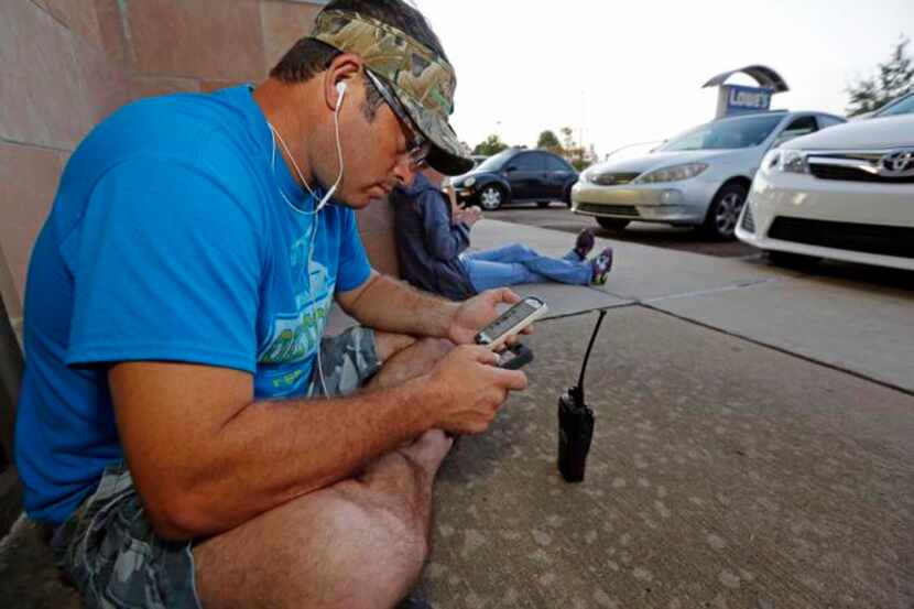 
Mark McManus waited in line last week outside a Verizon Wireless store in Flowood, Miss.,...