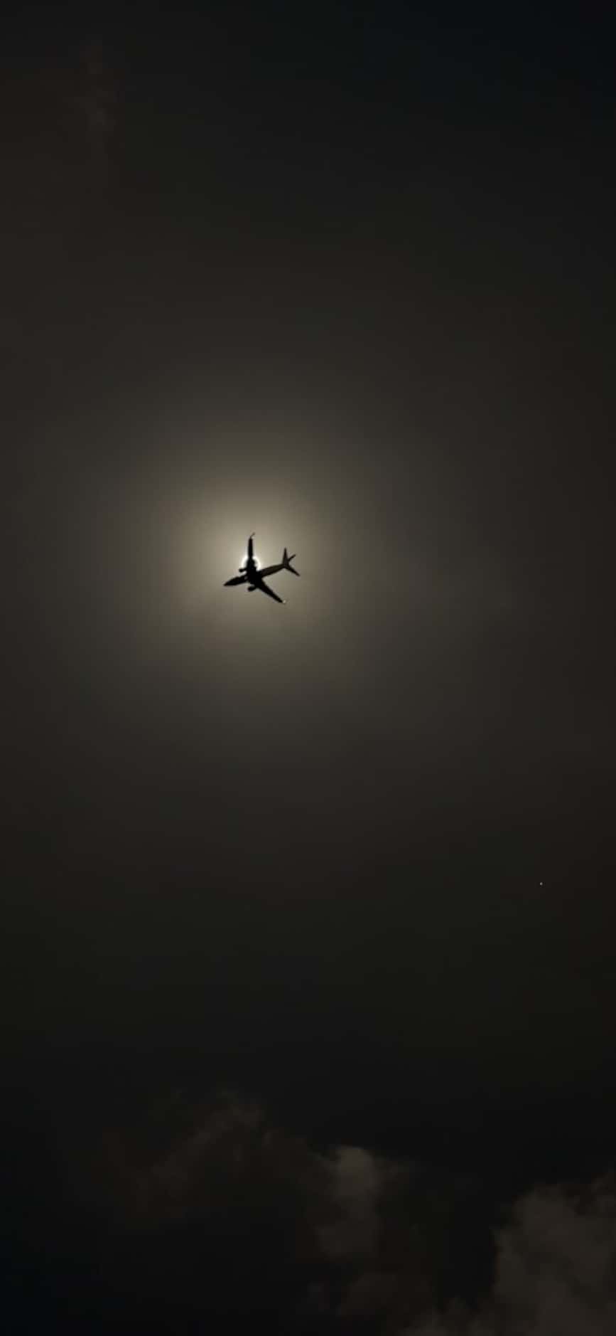 A plane passes across the solar eclipse in Dallas' Oak Lawn neighborhood. Provided by...