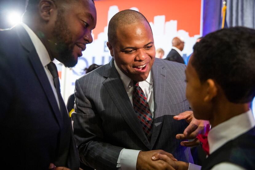 Mayor-Elect Eric Johnson shakes hands with Joseph Jackson Clayton, 13, as his father, Daniel...