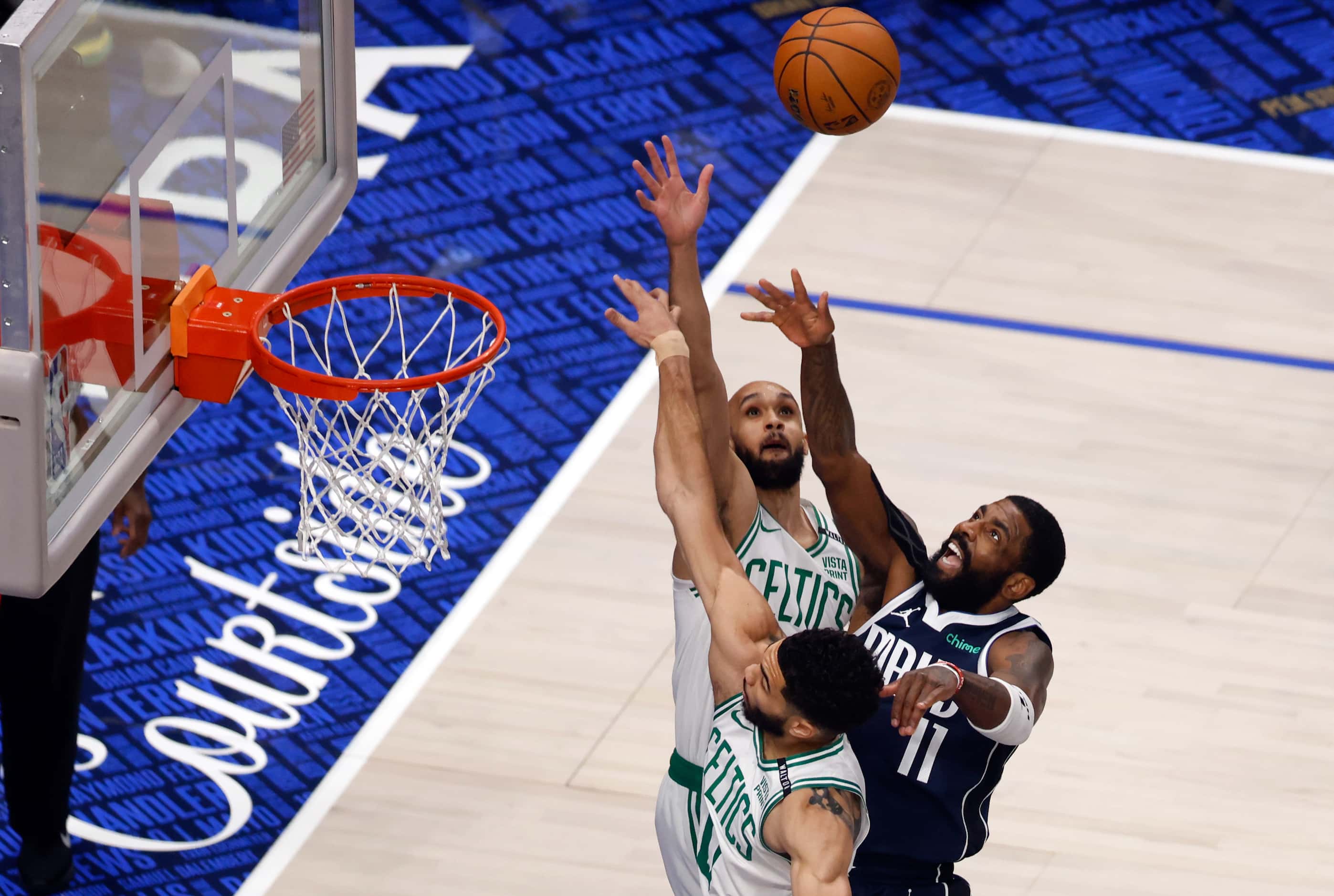 Dallas Mavericks guard Kyrie Irving (11) floats a shot over Boston Celtics guard Derrick...