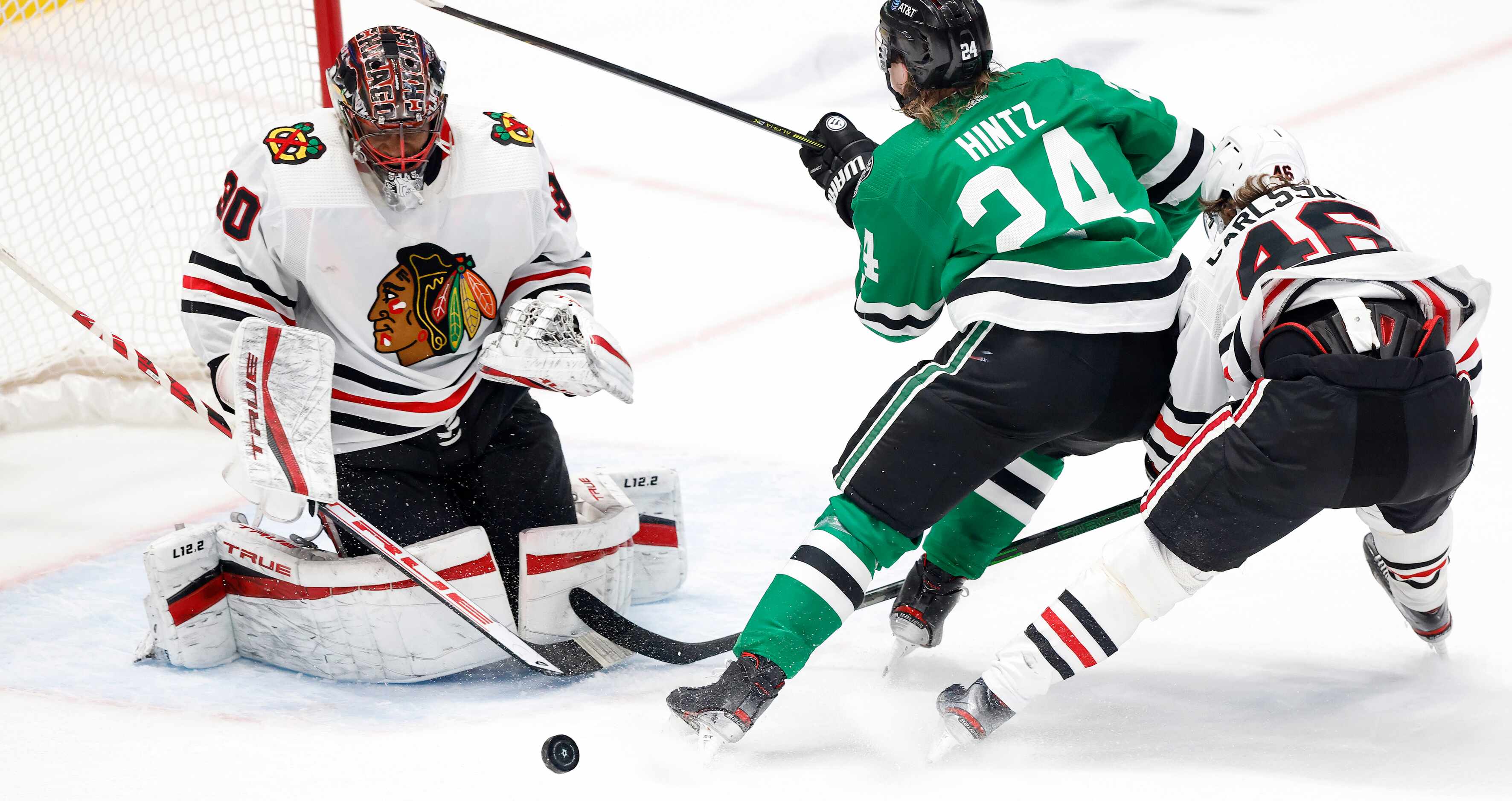 Dallas Stars left wing Roope Hintz (24) tries to stick a shot past Chicago Blackhawks...