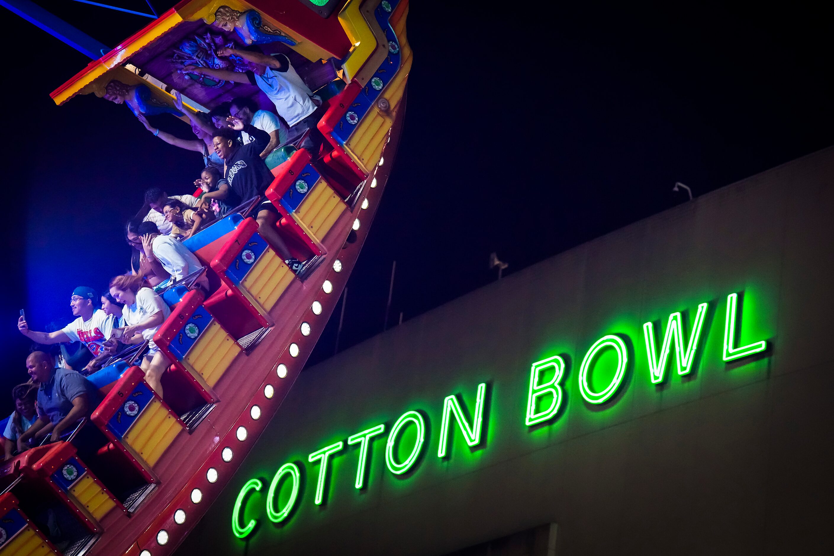 Fairgoers ride the Pirate on the midway on opening night at the State Fair of Texas on...