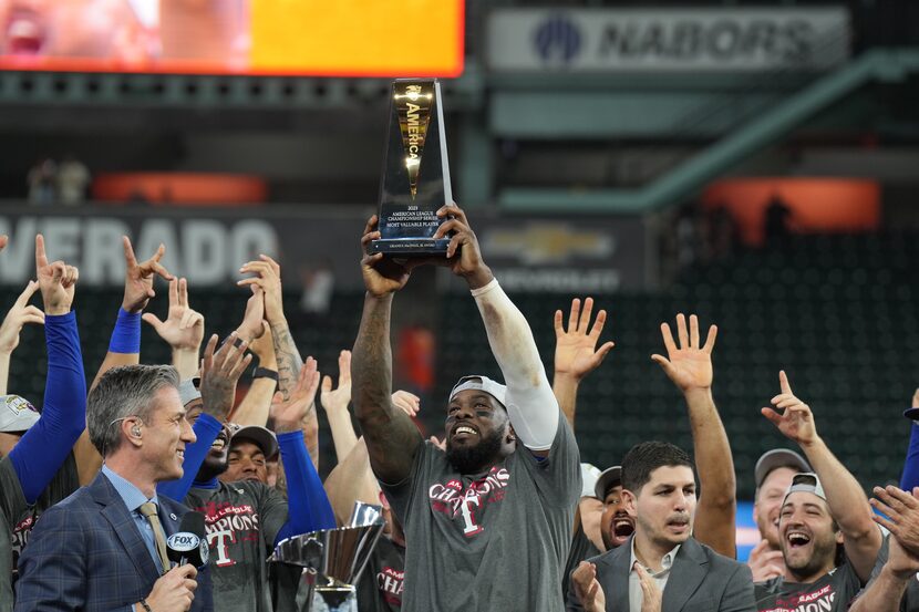 Texas Rangers right fielder Adolis Garcia (53) hoists up the ALCS MVP award after defeating...